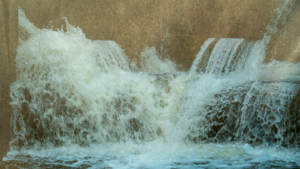 Water flowing over a concrete structure in a park during daytime © Сергей Семенов