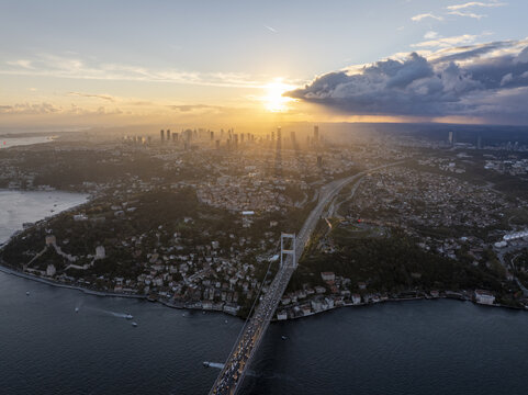 Aerial view of Fatih Sultan Mehmet Bridge spanning the Bosphorus at sunset with the Istanbul skyline in the background, Beykoz, Istanbul, Turkey.
