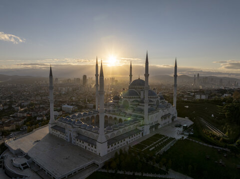 Aerial view of Grand Camlica Mosque at sunset with its grand domes and minarets overlooking the sprawling city skyline in Uskudar, Istanbul, Turkiye.