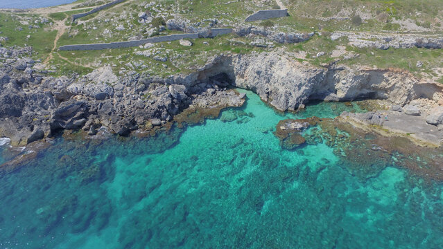 Aerial view of the rocky coastline and turquoise waters of Santa Maria di Leuca, Puglia, Italy.