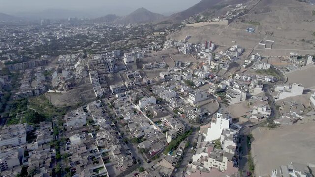 Aerial view of Casuarinas residential area featuring modern houses and winding streets nestled in the hills of Santiago de Surco, Lima, Peru.