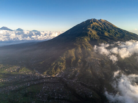 Aerial view of Mount Merbabu and the surrounding landscape of Selo, featuring lush green slopes, volcanic terrain, and scattered village houses in Selo, Central Java, Indonesia.