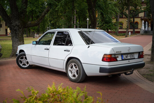 White Mercedes-Benz 200 D (W124) sedan (1984&ndash;1993), German executive sedan and oldtimer, rear three-quarter view in a city park. Parked in Palic, Serbia. July 4, 2026.