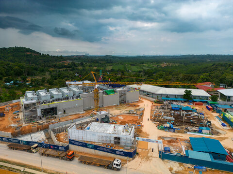 Aerial view of Data Center Nongsa construction site with a yellow tower crane, industrial buildings, and heavy machinery in Batam, Riau Islands, Indonesia.