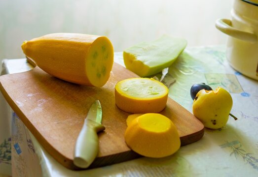 Chopping Organic Yellow Zucchini on a Rustic Board for Healthy Home Cooking