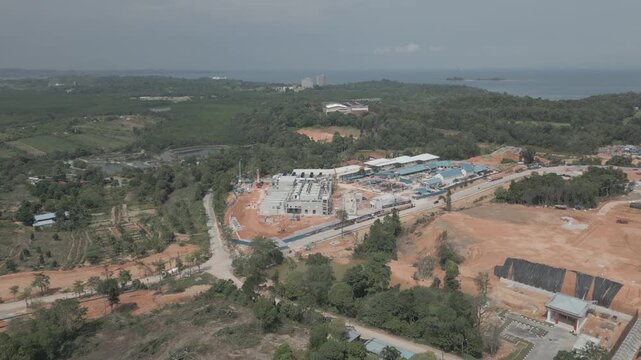 Aerial view of Data Center Nongsa construction site with surrounding forest and coastal landscape in Batam, Riau Islands, Indonesia.
