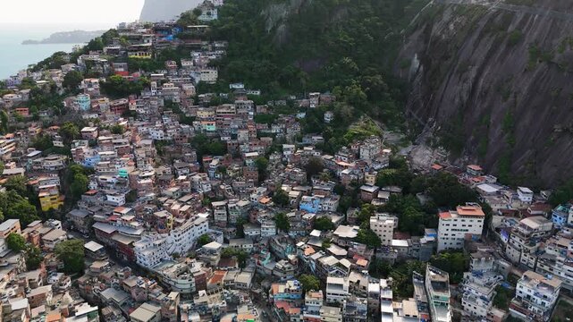 Aerial view of the dense urban landscape of a favela built on the steep hillsides with colorful houses and narrow alleyways in Rio de Janeiro, State of Rio de Janeiro, Brazil.