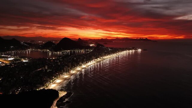 Aerial view of the illuminated Ipanema and Leblon beaches at night with city lights reflecting on the ocean in Rio de Janeiro, State of Rio de Janeiro, Brazil.