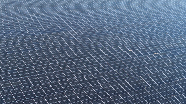 Aerial view of a vast solar farm with rows of photovoltaic panels capturing sunlight in the countryside, Lesser Poland Voivode, Poland.