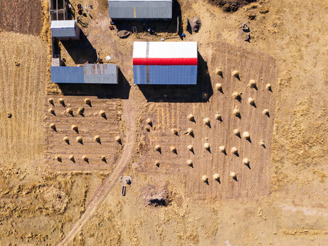 Aerial view of farmland with haystacks and farm buildings in Puno, Puno, Peru.