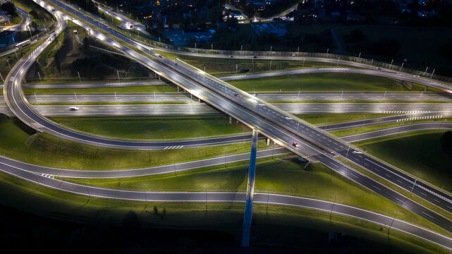 Aerial view of a highway interchange illuminated at night with traffic flowing along the roads in Krakow, Lesser Poland Voivode, Poland.