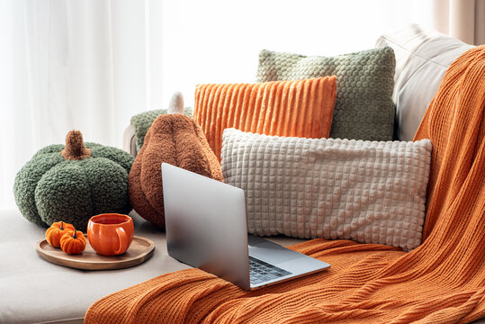Cozy Autumnal Home Scene With Laptop And Pumpkin Decor