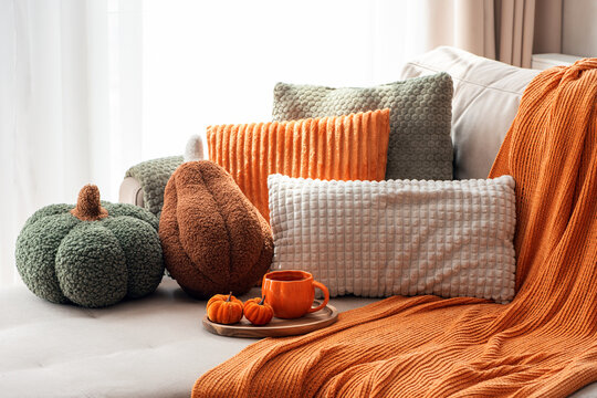 Cozy Autumn Home Decor Assortment With Pumpkins Pillows Blanket And Hot Beverage On Sofa