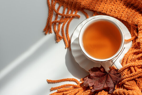 Warm Autumn Tea Cozy Scene with Orange Scarf and Fallen Leaf for Relaxation and Comfort