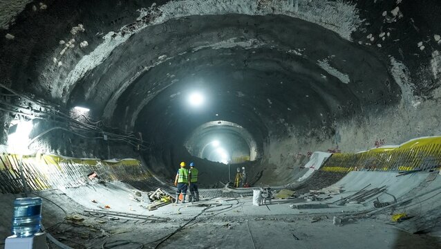 View of construction workers inside a large underground tunnel project with industrial lighting and reinforced concrete walls in Istanbul, Istanbul, Turkiye.