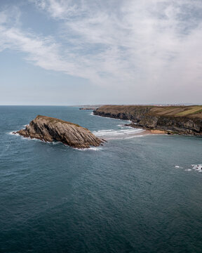 Aerial view of the dramatic rock formations and cliffs of Arnia Beach surrounded by the deep blue waters of the Cantabrian Sea, Cantabria, Spain.