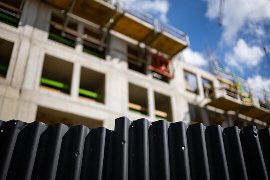 Blurred construction site over a fence. Abstract view of modern development in progress.