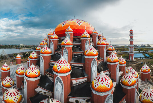 Aerial view of the Masjid Kubah 99 Asmaul Husna with its distinctive colorful domes and modern Islamic architecture situated along the coast in Kecamatan Mariso, Sulawesi Selatan, Indonesia.