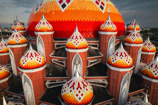 Aerial view of the vibrant and colorful domes of the Masjid Kubah 99 Asmaul Husna mosque featuring intricate geometric patterns in Kecamatan Mariso, Sulawesi Selatan, Indonesia.