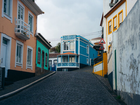 View of the historic cobblestone streets lined with colorful colonial-style buildings in the city center of Angra do Heroismo, Azores, Portugal.