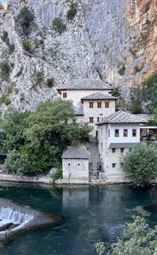View of Blagaj Tekke, a historic dervish monastery nestled against a limestone cliff beside the turquoise Buna river, with stone architecture in Mostar, Federation of Bosnia, Bosnia and Herzegovina.