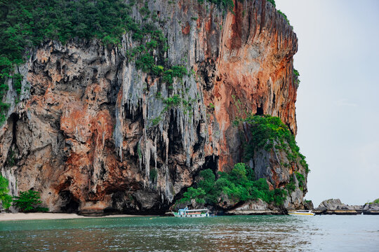 Majestic limestone karst cliff with dramatic rock formations rising from the sea near Railay Beach in Krabi, Thailand.