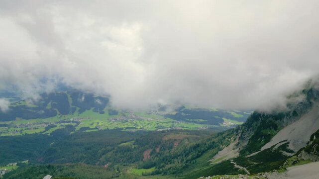 Aerial view of Ellmau from Wilder Kaiser mountains with lush green valleys and dramatic clouds over the alpine landscape in Ellmau, Tyrol, Austria.