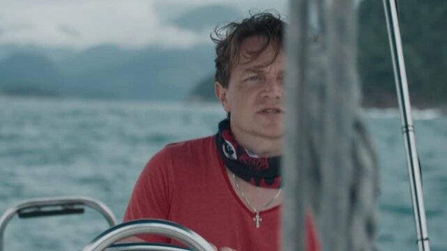 Young man steers the boat and sails the sea. Area of the town of Angra Dos Reis in Brazil