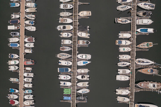 Aerial view of the marina with numerous boats docked in neat rows along wooden piers in Vilanova de Arousa, Pontevedra, Spain.