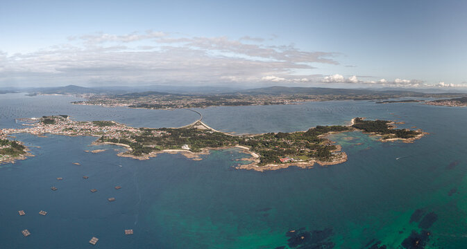 Aerial view of A Illa de Arousa, featuring the bridge connecting the island to the mainland, surrounded by the Atlantic Ocean and mussel rafts, A Illa de Arousa, Pontevedra, Spain.