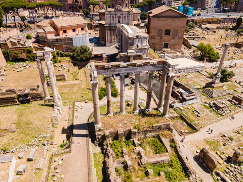 Aerial view of the Temple of Saturn in the Roman Forum with ancient stone columns, ruins, and surrounding historic architecture in Roma, Lazio, Italy.
