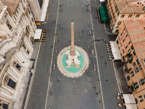 Roma, Italy - 13 July 2021: Aerial view of Fontana dei Quattro Fiumi in Piazza Navona, with its central obelisk, turquoise pool, historic buildings, and pedestrians on the square.