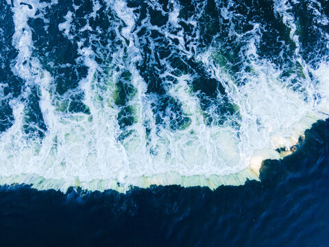 Aerial view of Venta Rapid, the widest waterfall in Europe, with cascading white water and deep blue river currents in Kuldiga, Kuldiga Municipality, Latvia.