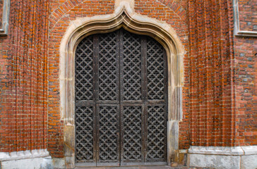 Beautiful vintage metal door on the brick wall, St. Mary's basilica, Gdansk, Poland © Blazenka