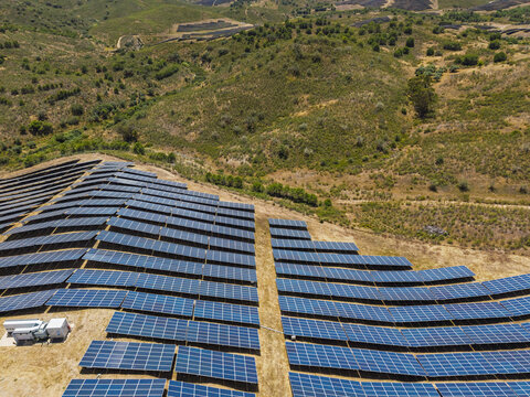 Aerial view of solar panels installed on a hillside in the rural landscape of Vaqueiros, Faro District, Portugal.