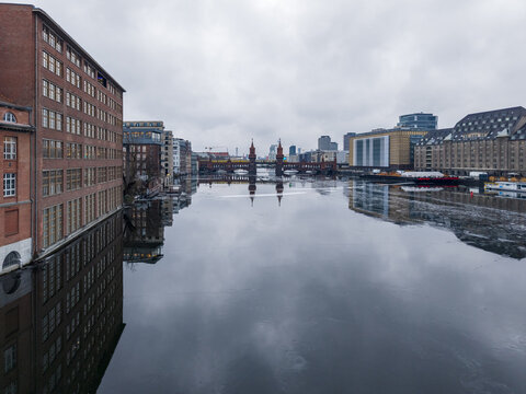 Aerial view of the historic Oberbaumbrucke spanning the Spree river, surrounded by brick architecture under an overcast sky in Berlin, Berlin, Germany.