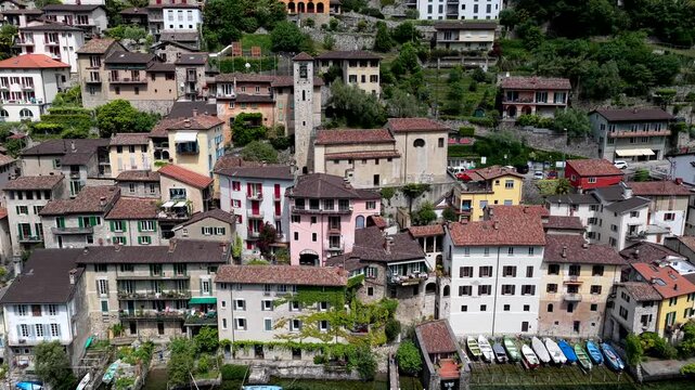 Aerial view of the historic village of Gandria with stone buildings and small boats moored along the shore of Lake Lugano in Lugano, Ticino, Switzerland.