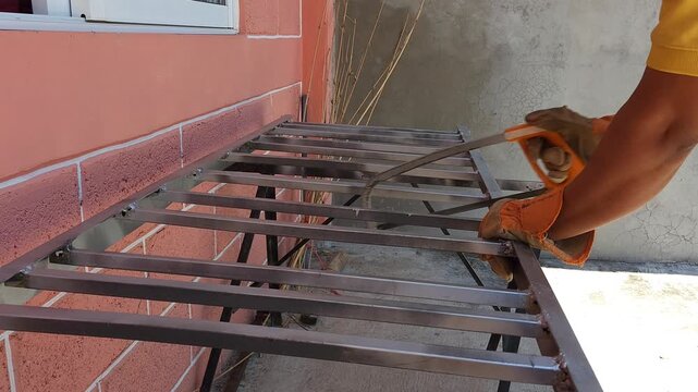 Worker Cutting Metal Iron Base Frame Using Angle Grinder