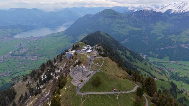 Aerial view of Stanserhorn Cabrio mountain station, featuring panoramic views of the Swiss Alps, lush green slopes, and the valley below in Stans, Nidwalden, Switzerland.