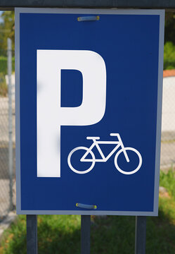 Blue bicycle parking sign showing letter P and bike icon outdoors