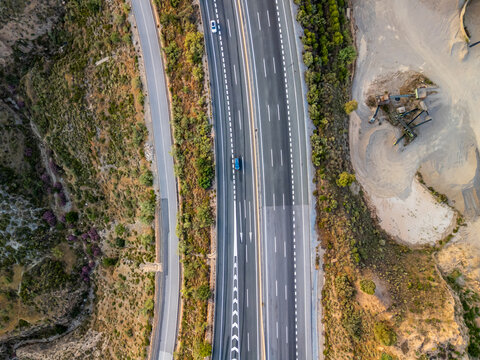 Aerial view of a highway winding through the hilly landscape of Velez de Benaudalla, Andalusia, Spain.