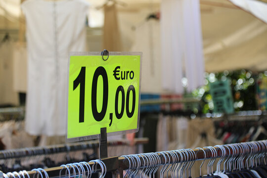 bright green ten euro price tag on a clothing rack at an outdoor market