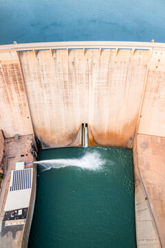 Aerial view of the Presa de Rules dam showing the concrete wall, water discharge, and reservoir in Granada, Andalucia, Spain.