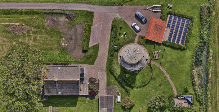 Lage Zwaluwe, Netherlands - 04 June 2026: Aerial view of the former Polder Schuddebeurs drainage mill stone tower, now a house, with solar panels and green fields.