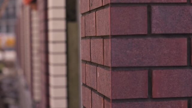 Red brick facade of residential building under construction close up