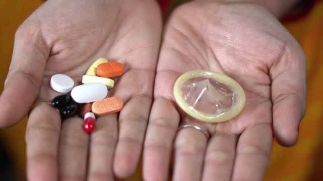 Birth control pills and condom for contraception options. offering choice between contraceptive pills and latex condom for sexual health education. pills and condom representing birth control methods.