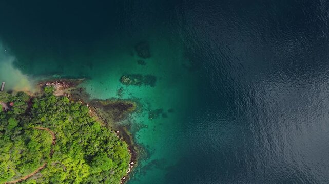 Aerial top down view of the calm and green lagoon with crystal clear water near the island of Ilha Grande, Brazil