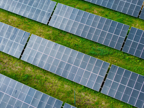Aerial view of solar panels arranged in rows across a green field in Olaine, Olaine Municipality, Latvia.