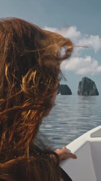 Red-haired woman enjoys a peaceful boat ride with a view of tropical islands in el nido, philippines