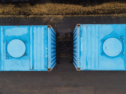 Aerial view of two blue shipping containers on a freight train in Riga, Latvia.